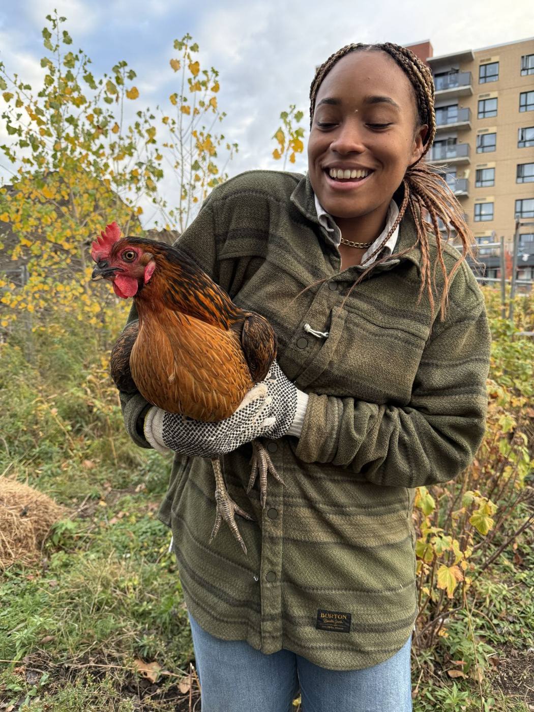 Une membre tient une poule du poulailler