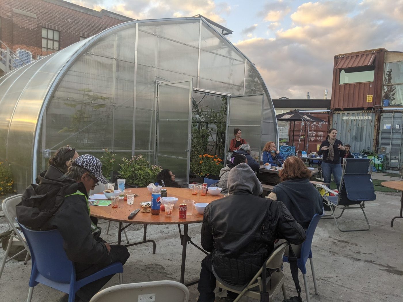 A shared meal in front of La Fermette’s greenhouse